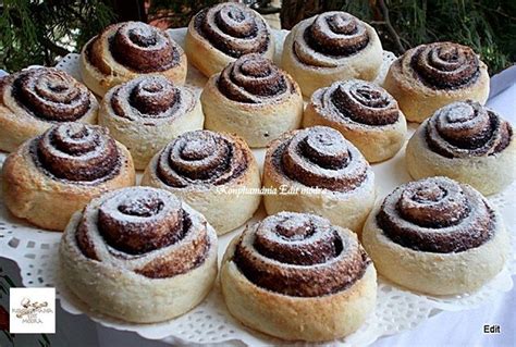 A White Plate Topped With Lots Of Cinnamon Buns Covered In Powdered