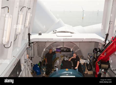 Engineers working in the nacelle of a wind turbine at the Walney Stock ...