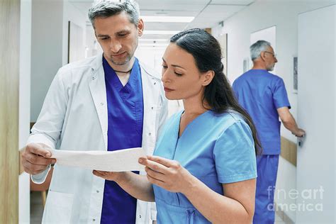 Doctor And Nurse Discussing Patient Care By Peakstock Science Photo