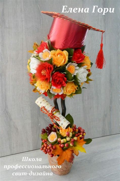 An Arrangement Of Flowers In A Vase With A Graduation Hat On Top That