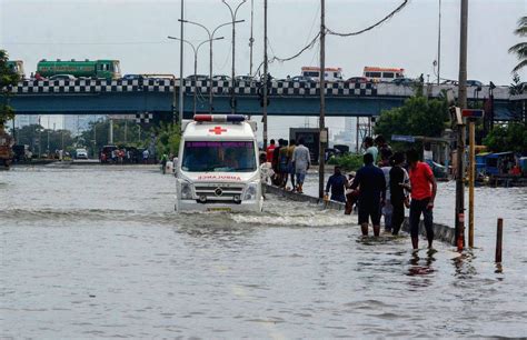 People Wade Through A Flooded Road After Heavy Rainfall Owing To