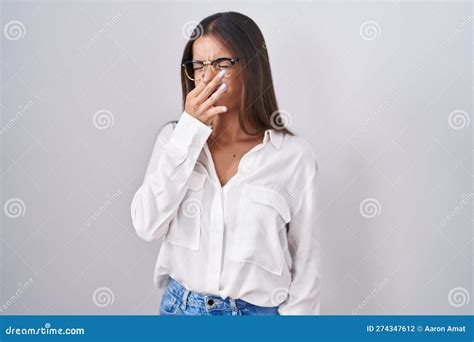 Young Brunette Woman Wearing Glasses Smelling Something Stinky And