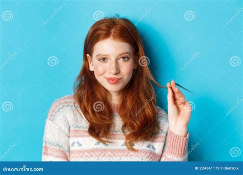 Close Up Of Confident And Sassy Redhead Teen Girl Looking At Camera Pleased Playing With Hair