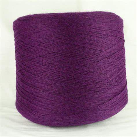 Purple Yarn Is Spooled On A White Surface