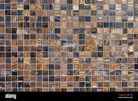 Small square mosaic wall tiles in brown and gold Stock Photo - Alamy