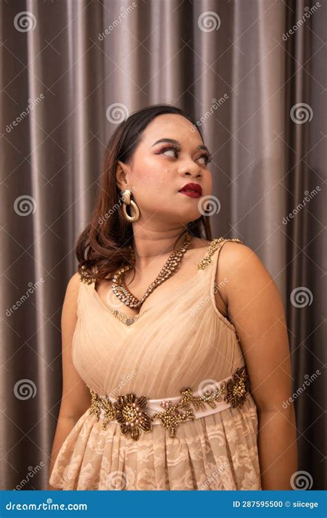 An Asian Woman Wearing A Brown Dress While Attending A Prom Night At