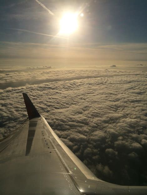 El ala de un avión volando sobre las nubes Foto Premium