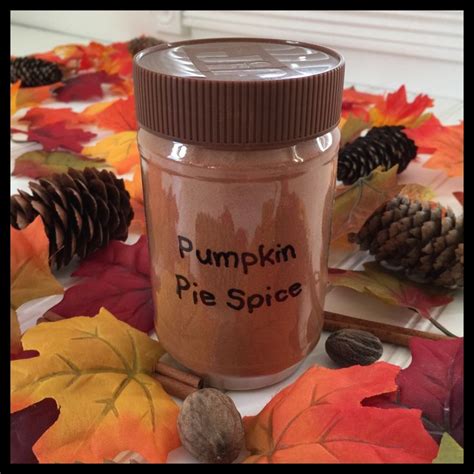 a jar filled with pumpkin pie spice surrounded by autumn leaves and ...