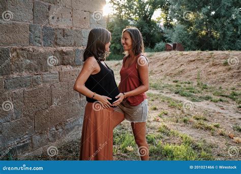 Closeup Of A Pregnant Lesbian Couple Doing A Photoshoot In A Park Stock