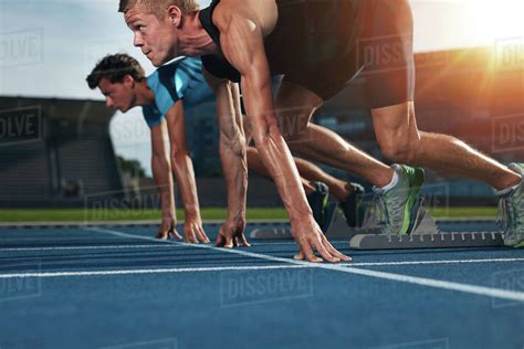 Two Young Athletes At Starting Position Ready To Start A Race