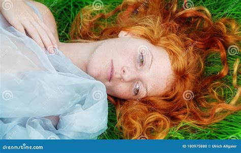 Portrait Of A Beautiful Young Red Haired Woman Lying In The Spring Sun