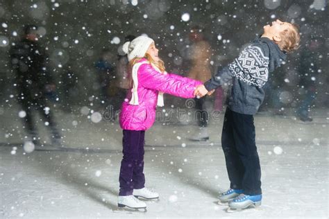 Patinagem No Gelo Feliz Na Pista De Gelo Noite Das Crianças Do Inverno