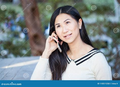 Beautiful Asian Woman Talking On The Phone With A Smile On Her F Stock