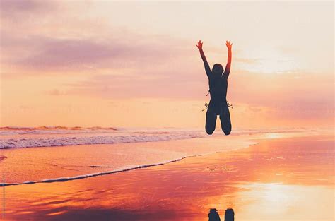 "Silhouette Of An Excited Girl Jumping On The Beach" by Stocksy Contributor "Wizemark" - Stocksy