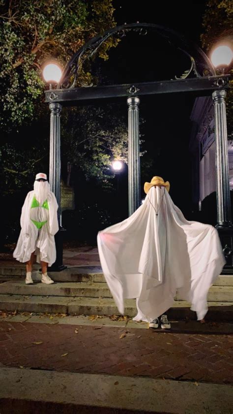 Two People Dressed In White Standing On Steps At Night With Ghost