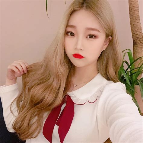 A Woman With Long Blonde Hair Wearing A Red Tie And White Shirt Posing