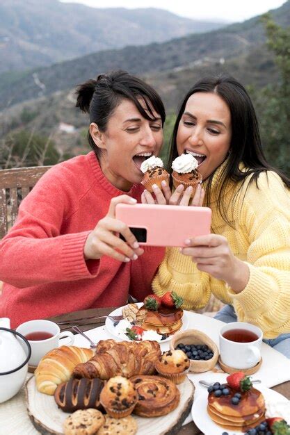 Mujeres De Tiro Medio Comiendo Cupcakes Foto Gratis