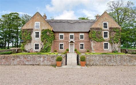 An Old Brick House With Ivy Growing All Over It