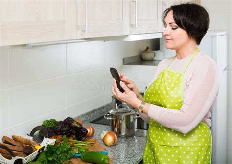 Housewife In Apron Taking Photo Of Dinner Indoors Stock Image Image Of European Housekeeping