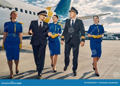 Aviators And Beautiful Flight Attendants Going Ahead Stock Image