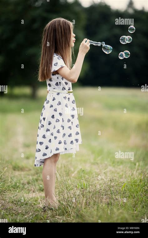 Jeune Fille Soufflant Des Bulles De Savon Par Le Lac Photo Stock Alamy