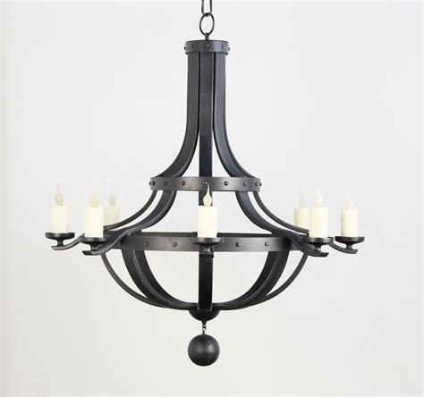 A Chandelier With Six Candles Hanging From Its Center And Four Arms