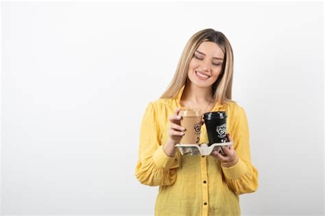 Portrait De Jeune Fille Regardant Des Tasses De Café Sur Blanc Photo