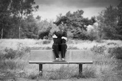 La Jeune Femme Triste Déprimée Seule Sasseyant Sur Un Banc Avec Des