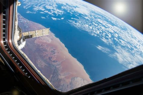 Vue De La Planète Terre Bleue Depuis La Station Spatiale De La Fenêtre