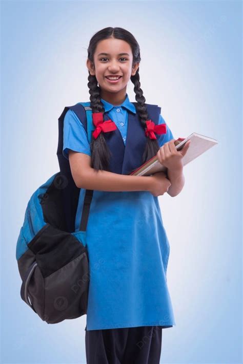 Portrait Of School Girl In Uniform Holding Book And Bag Photo