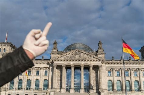 Premium Photo | Hand with latex gloves giving german bundestag in ...