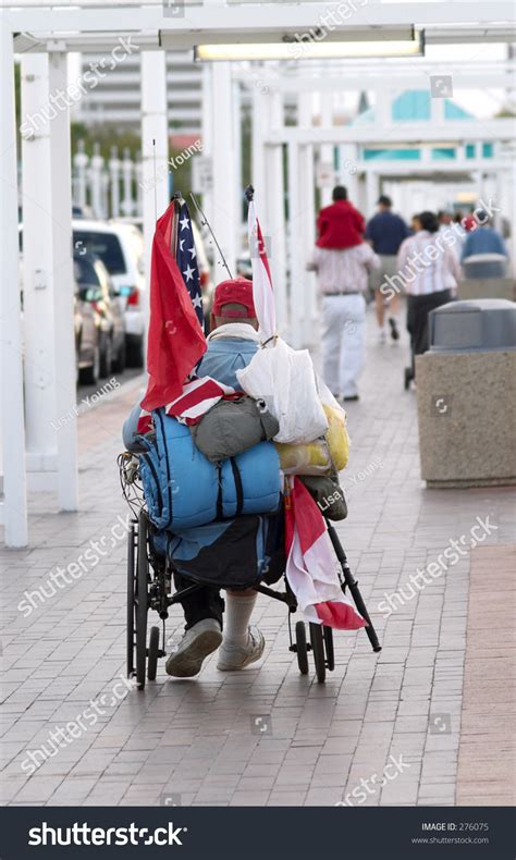 A Homeless Veteran In A Wheelchair With The American Flag And His