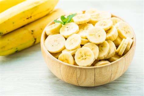 Fatias de banana amarela crua na tigela de madeira Foto Grátis