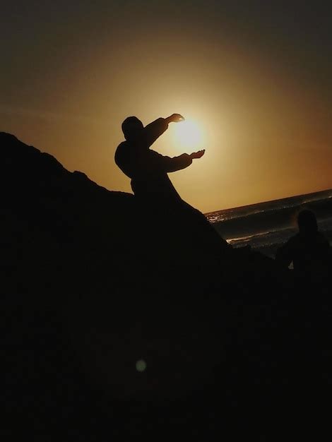 Ilusi N Ptica De Silueta De Un Hombre Sosteniendo El Sol En La Playa