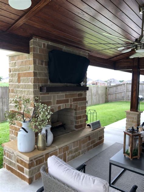 Covered patio with fireplace built by Backyard Retreats ...