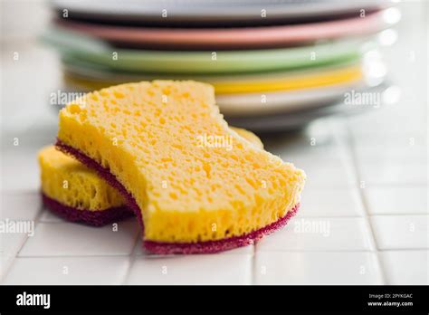 Sponge for washing dishes and plates on the tiles Stock Photo - Alamy