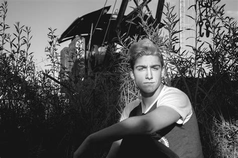 Premium Photo Portrait Of Young Man Sitting Against Plants