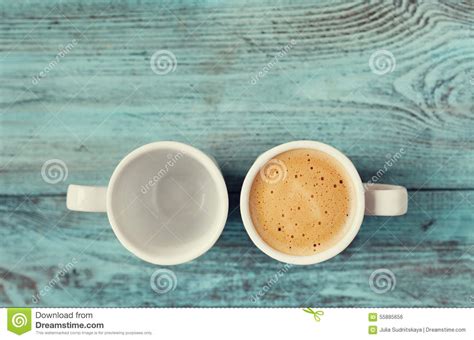 Empty And Full Cup Of Fresh Coffee On Vintage Blue Table Stock Photo