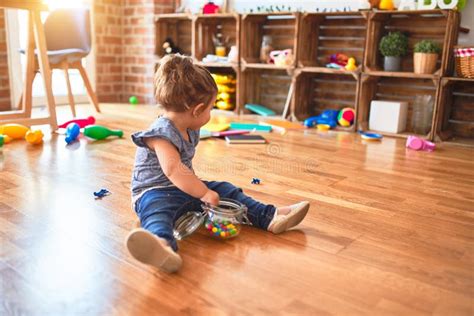 Beautiful Toddler Sitting On The Floor With Jar Of Chocolate Colored