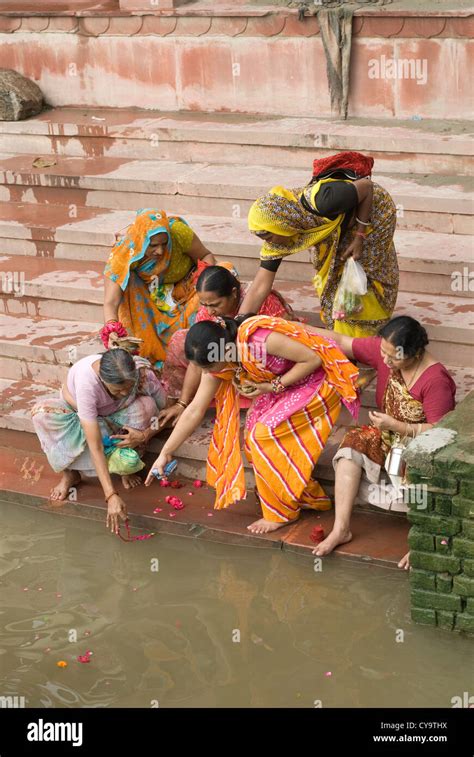 Hindu Devotees Cast Offerings Into The Sacred Yamuna River At Vishram