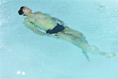 Man Floating On Back In Swimming Pool Eyes Closed Stock Photo Dissolve