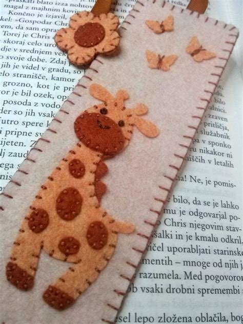 Two Felt Giraffes Sitting On Top Of An Open Book