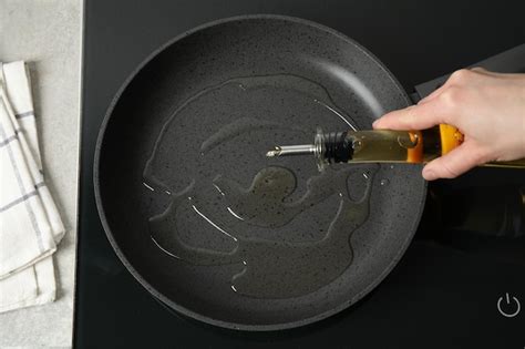 Premium Photo Woman Pouring Cooking Oil From Bottle Into Frying Pan