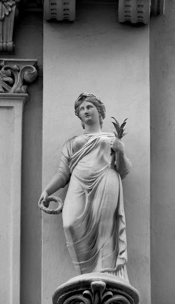 En Una Pared Hay Una Estatua De Una Mujer Con Alas Y Una Pluma Foto