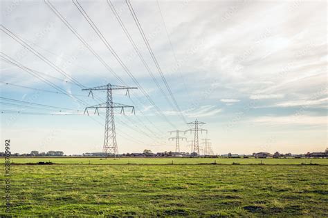 Row Of Power Pylons With High Voltage Lines In A Dutch Polder Landscape