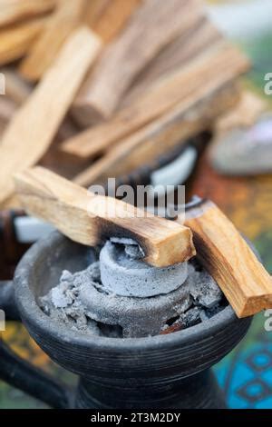 Burning Palo Santo Stick With Smoke On Wooden Stand Over Red Orange