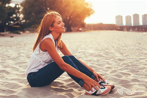 Young Happy Woman Sitting On The Beach Sand And Smiling Young Happy