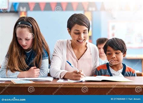 Youre Doing Really Well A Cheerful Young Female Teacher Helping Her