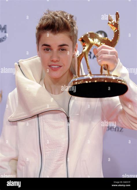 Singer Justin Bieber Poses With The Entertainment Bambi Trophy In The