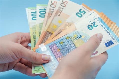 Manos De Mujer Sosteniendo Una Pila De Dinero Euro Sobre Fondo Azul